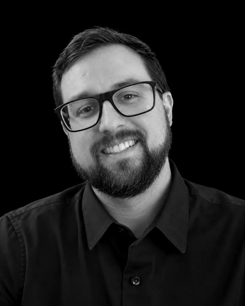 Michael Doyle, smiling, in glasses and a dark shirt